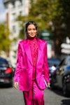 Wearing fall 2022 fashion trends for pink auras, Nikki Huang wears diamond earrings, a neon pink ruf...